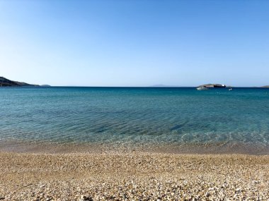 Yunanistan 'da plaj. Temiz deniz suyu ve ıslak küçük çakıl taşları. Andros Yunan adasında yaz tatili
