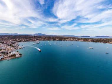 Yunanistan, Mora 'nın Argolis kentindeki bir yaz tatil beldesi olan Porto Cheli' nin insansız hava aracı görüntüsü. Kıyıdaki deniz kenarındaki binalar ve denizdeki tekneler, mavi gökyüzü.