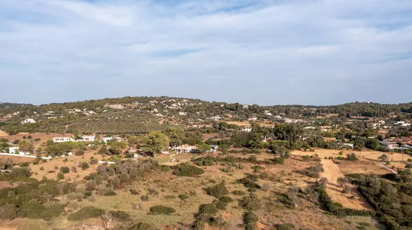Yunanistan, Mora 'nın Argolis kentindeki bir yaz tatil beldesi olan Porto Cheli' nin insansız hava aracı görüntüsü. Tepedeki binalar ve ağaçlar, bulutlu mavi gökyüzü