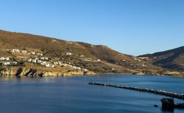 Stone breakwater with a lighthouse at the entrance of the port of Gavrio, Andros island Cyclades, clipart