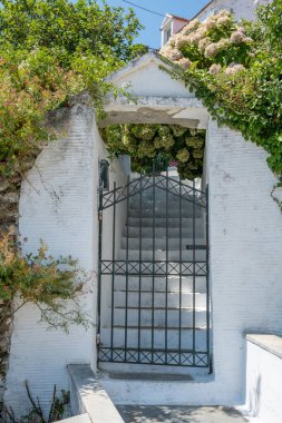 Yunanistan. Kapalı metal kapı, beyazlatılmış taş merdiven Yunan adasında geleneksel ev girişi, güneşli yaz günü..