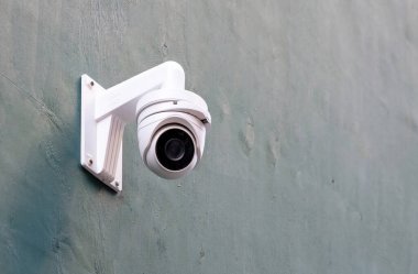 Gri duvardaki güvenlik kamerası, CCTV izleme sistemi ekipmanları.