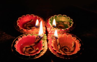 Diwali Hindu Işık Festivali. Çiçek dekorasyonlu kırmızı zemin üzerinde Diyas yağı lambaları, kopyalama alanı