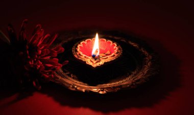 Diwali Hindu Işık Festivali. Çiçek süslemeli kırmızı arkaplanda Diya yağı lambası