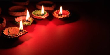 Diwali Deepavali Hindu Işık Festivali Kutlaması. Drak kırmızı zemin üzerinde Diya yağ lambaları, kopyalama alanı