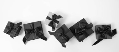 Kara Cuma indirimi konsepti. Kurdeleli siyah hediye kutuları beyaz, üst görünümde izole