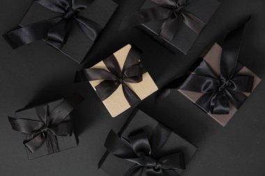 Kara Cuma indirimi konsepti. Siyah arka planda kurdele ile siyah hediye kutuları, üst görünüm