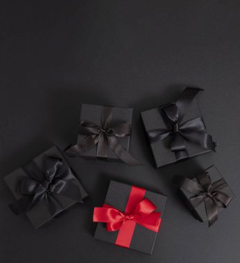 Kara Cuma indirimi. Siyah hediye kutuları ve siyah kurdele yayları, üst görünümde izole edilmiş, boşluğu kopyala,