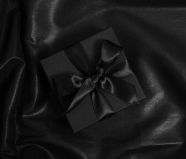 Kara Cuma indirimi. Kurdeleli hediye kutusu ve siyah saten üzerinde yay, üst görünüm, boşluk kopyala