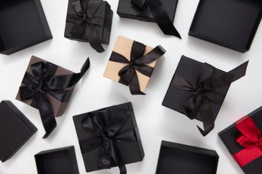 Kara Cuma indirimi konsepti. Beyaz arka planda kurdele ile siyah hediye kutuları, üst görünüm