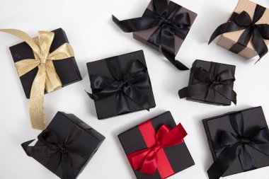 Kara Cuma indirimi konsepti. Beyaz arka planda kurdele ile siyah hediye kutuları, üst görünüm