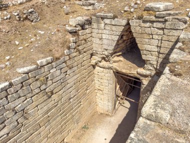 Clytemnestra 'nın Yunanistan' daki Mycenae arkeoloji sahasındaki mezarı. Mavi gökyüzü, güneşli bir gün. Mycenaean tholos tipi mezar yan görünümün üzerinde
