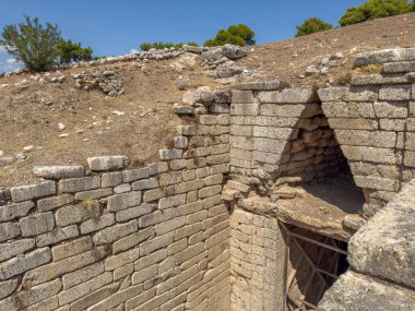 Clytemnestra 'nın Yunanistan' daki Mycenae arkeoloji sahasındaki mezarı. Mavi gökyüzü, güneşli bir gün. Mycenaean tholos tipi mezar yan görünümün üzerinde