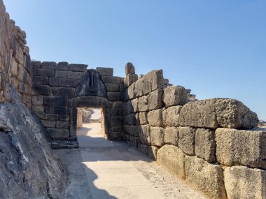 Yunanistan 'ın Mycenae arkeolojik sahasında aslan kapısı ve siklopedi ustalığı. Kalenin ana girişi, mavi gökyüzü.