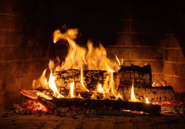 Пламя огня, дрова в камине. Теплый дом зимой, жара. Рождественский праздник