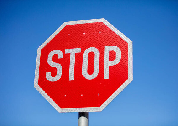 Stop sign against clear blue sky, Red color traffic road warning sign