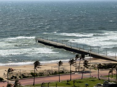 Durban plajı, gezinti güvertesindeki palmiye ağaçları ve fırtınalı Hint okyanusu, Güney Afrika. Yukarıdan görüntüle
