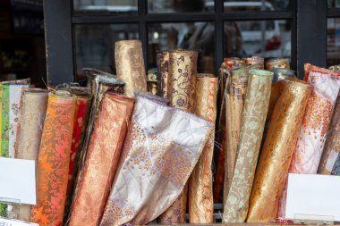 Japanese textiles collection at a shop display, Rolls of fabric with ornate patterns, brocade and silk, used for traditional kimono clipart