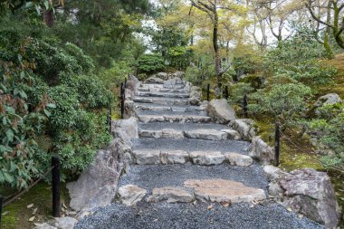 Japon bahçesindeki merdivenler, doğal taş merdivenler, yeşil bitkiler ve ağaçlar. Japonya 'da bahar