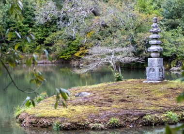 Bir bahar günü göletli Japon bahçesi, Taş fener ve yemyeşil, yosun kaplı kayalar, sakin su, bahar zamanı