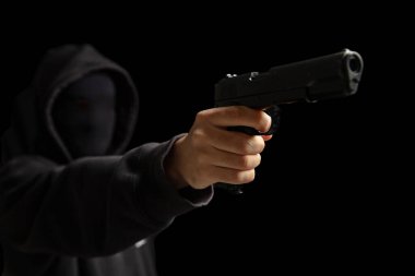 Siyah kapüşonlu silahlı soyguncu ateş etmeye hazır. Silahlı gangster suçlu, katil. Silah, şiddet kavramı
