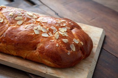Paskalya tatlı ekmeği, ahşap bir masada ev yapımı tsoureki örgü, yakın çekim manzarası.