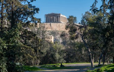 Athens, Greece. Parthenon on Acropolis hill and Herodeion, clear blue sky.  clipart