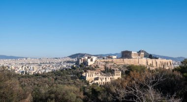 Athens, Greece. Parthenon and Propylaea, Acropolis hill, Herodeion and mount Lycabettus, blue sky. clipart