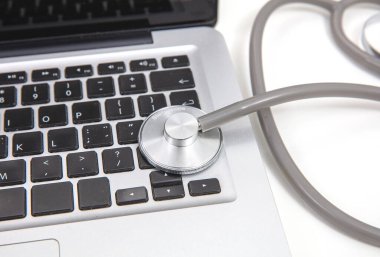 Teletıp, tıbbi steteskop ve bilgisayar bilgisayarı beyaz, yakın çekim görüntüsü