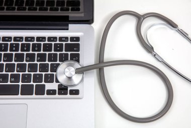 Teletıp, tıbbi steteskop ve beyaz üzerine bilgisayar bilgisayarı.