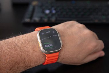 28 Ocak 2025. Atina Yunanistan. Erkek bileğinde Apple akıllı saati, yakın plan. Apple smartwatch ultra, turuncu renkli spor bandı