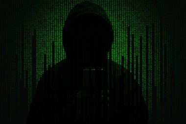Matrix kod arka planında kapüşonlu bir korsan. Siber suç konseptini dolandırmak