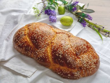 Paskalya tatlı ekmeği, ev yapımı tsoureki örgü ve masada Paskalya süslemesi, yakın çekim manzarası.