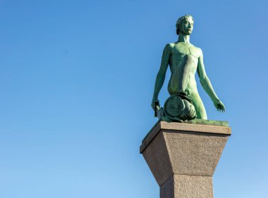 David ve Goliath heykeli taş bir kaidede, mavi gökyüzü arka planında. Zürih İsviçre