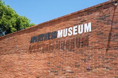 Johannesburg, Güney Afrika. 22 Ekim 2024. Irkçılık Müzesi tabelası, müzenin girişindeki kırmızı tuğlalı duvara yazı yazma.