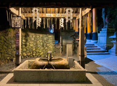Kyoto, Japonya. 7 Nisan 2024. Geceleri Fushimi Inari Taisha 'daki Japon tapınağı arıtma çeşmesi.