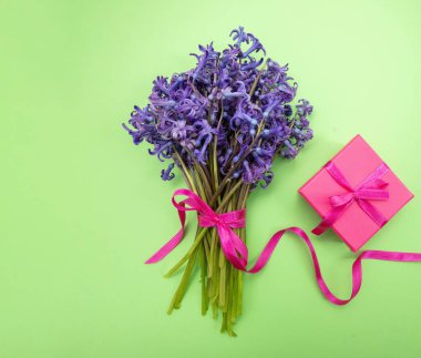 Anneler günü hediyesi. Taze mavi sümbüller çiçek buketi ve bir hediye kutusu, üst manzara.