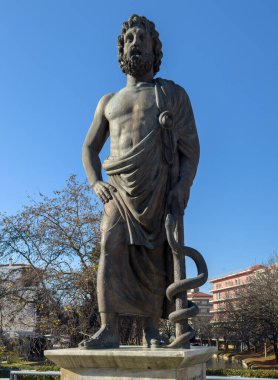 Yunanistan 'ın Trikala şehrinde Asclepius heykeli. Kış güneşli gün, açık mavi gökyüzü