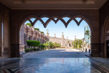 Arabesk mimarisi, kemerli pencereler ve palmiye ağaçları Abu Dabi 'deki Emirates Sarayı Oteli. Birleşik Arap Emirlikleri.