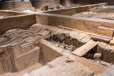 Xian, Çin. Terracotta Army Warriors arkeolojik alanı. Kısmen kazılmış. Dalgalanan toprak, gömülü parçaları örter.