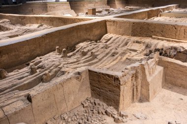 Terracotta Army Warriors arkeolojik alanı. Xian, Çin. Kısmen kazılmış. Dalgalanan toprak, gömülü parçaları örter.