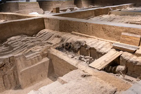 Xian, Çin. Terracotta Army Warriors arkeolojik alanı. Kısmen kazılmış. Dalgalanan toprak, gömülü parçaları örter.