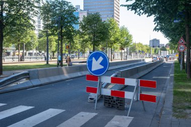 Şehir merkezinde yol çalışması, sokak şeridi barikatla kapalı, yol ayrımı trafik ışıkları ve modern mimari binalar
