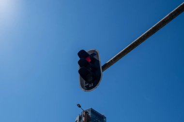 Arabalar için kırmızı trafik ışığı, mavi gökyüzü arka planı, güneşli gün.