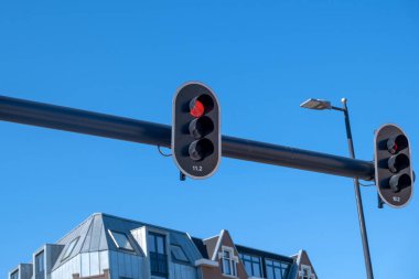 Arabalar için kırmızı trafik ışığı, mavi gökyüzü ve geleneksel Hollanda mimari binaları, Rotterdam Hollanda