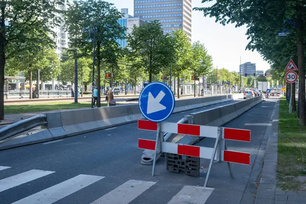 Şehir merkezinde yol çalışması, sokak şeridi barikatla kapalı, yol ayrımı trafik ışıkları ve modern mimari binalar
