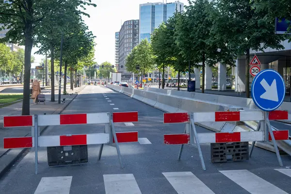 Şehir merkezinde yol çalışması, sokak şeridi barikatla kapalı, yol ayrımı trafik ışıkları ve modern mimari binalar