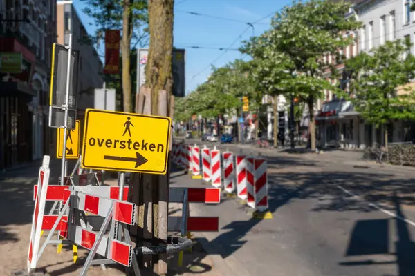 Yayalar için geçici şerit, Rotterdam 'da yol bakım işleri. Flaman metniyle sarı sapma işareti, İngilizce geçiş