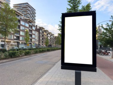 Boş reklam standı, kaldırımda boş dikey ilan panosu. Modern binalar. Hollanda 'da reklam şablonu
