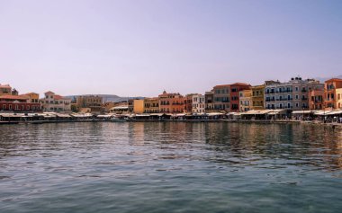 Chania eski kasaba manzarası. Eski Venedik limanındaki geleneksel rıhtım binaları ve dükkanlar, güneşli bir gün, mavi gökyüzü